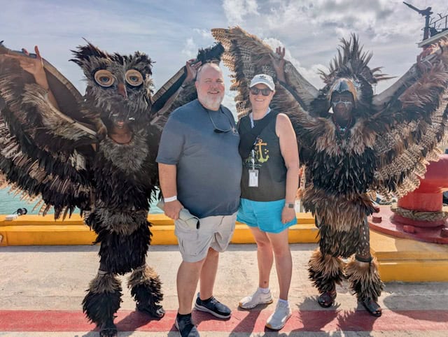 Travel advisors with costumed characters at outdoor event in sunny weather.